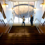 Two people standing at the top of the stairs with the water tower behind them.