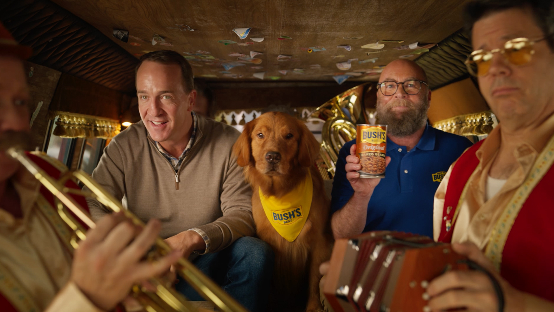 Peyton Manning, Duke, and Jay Bush ride in an SUV with two musicians in Bush’s Beans tv ad.