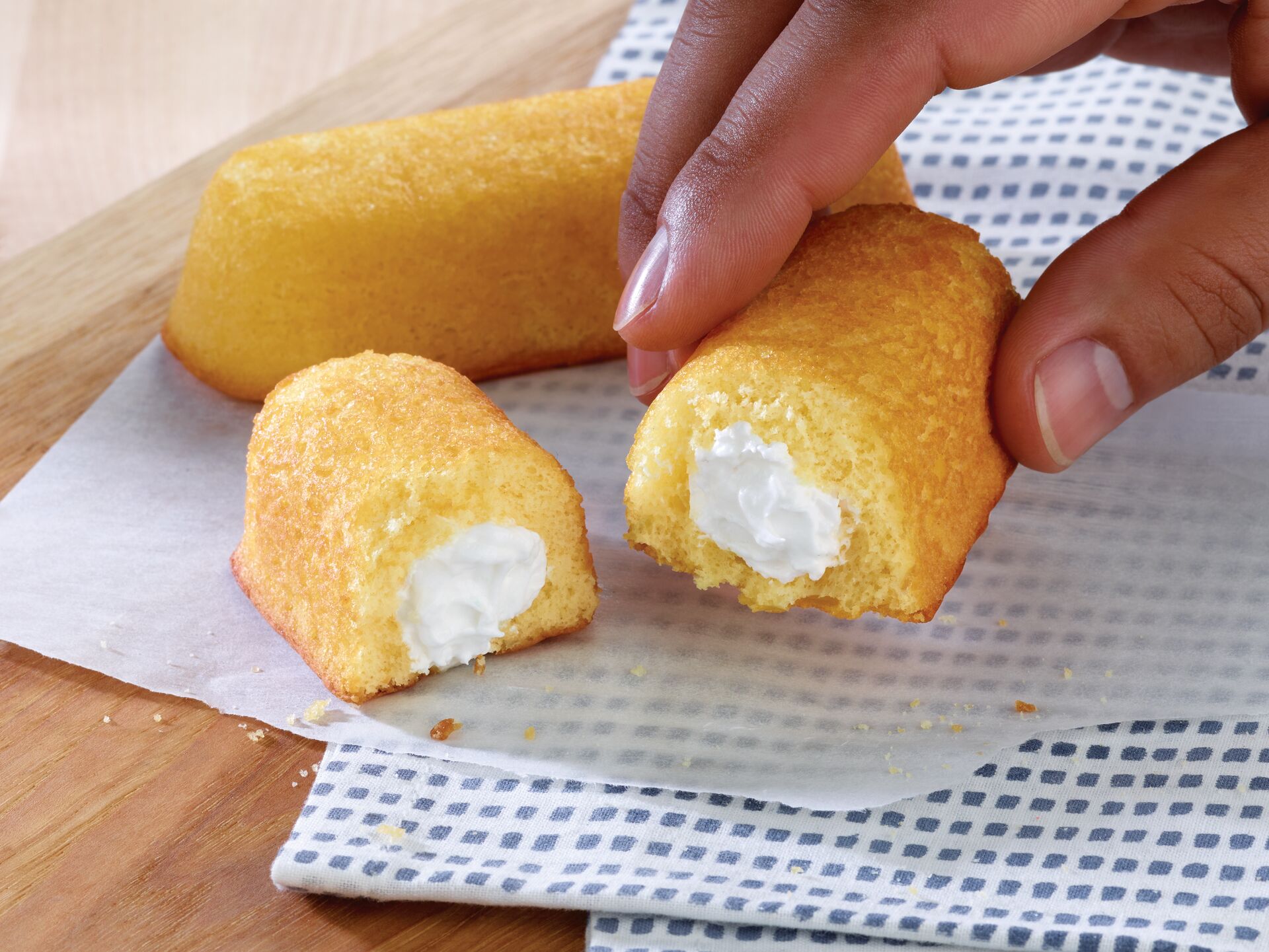 A hand holding half of a Twinkie.