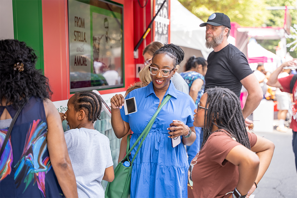 People next to the Stella booth at a festival.